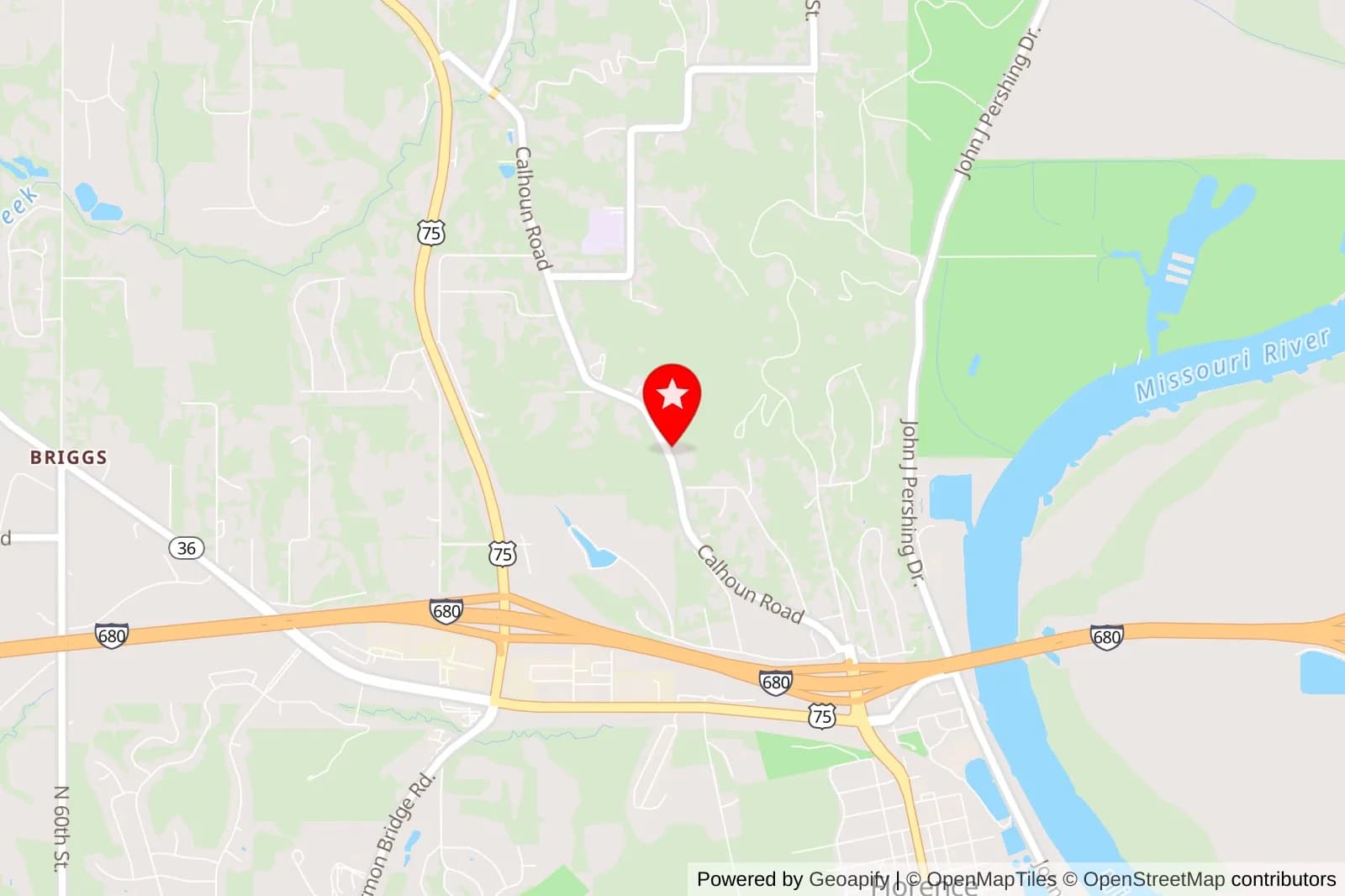 Map showing a red location pin near Calhoun Road, I-680, and the Missouri River north of Omaha